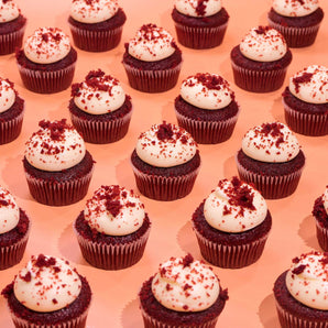 Vegan Red Velvet Cupcakes by Crumbs & Doilies with plant-based vanilla icing and red velvet crumb topping on peach background